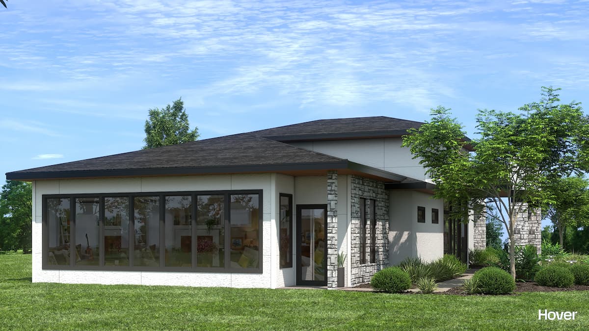 Contemporary house with expansive glass windows and lush garden landscaping.