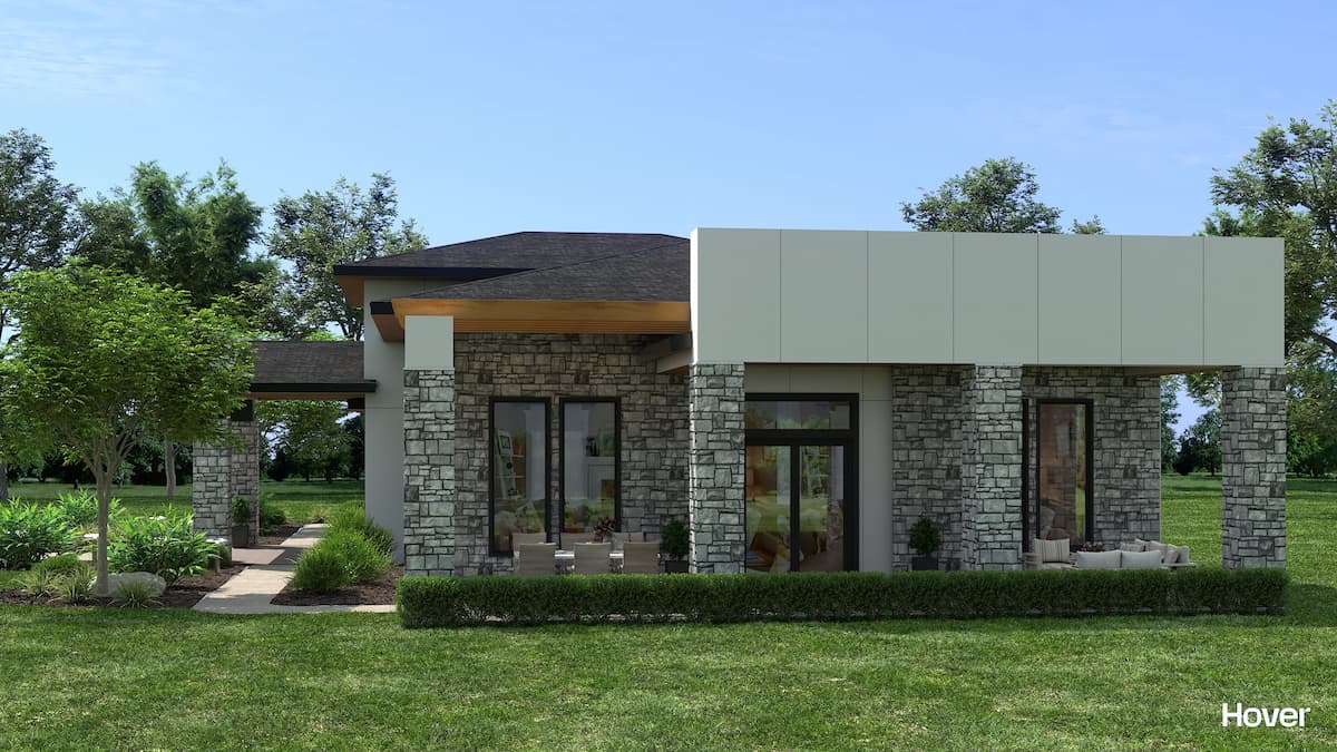 Contemporary house with stone facade, large windows, and lush landscaping.